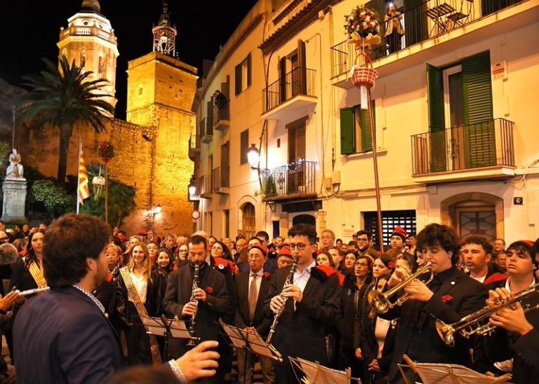 Eine Gruppe von Caramellaires singt und spielt Blasinstrumente durch die Gassen der Altstadt von Sitges während der Karwoche.