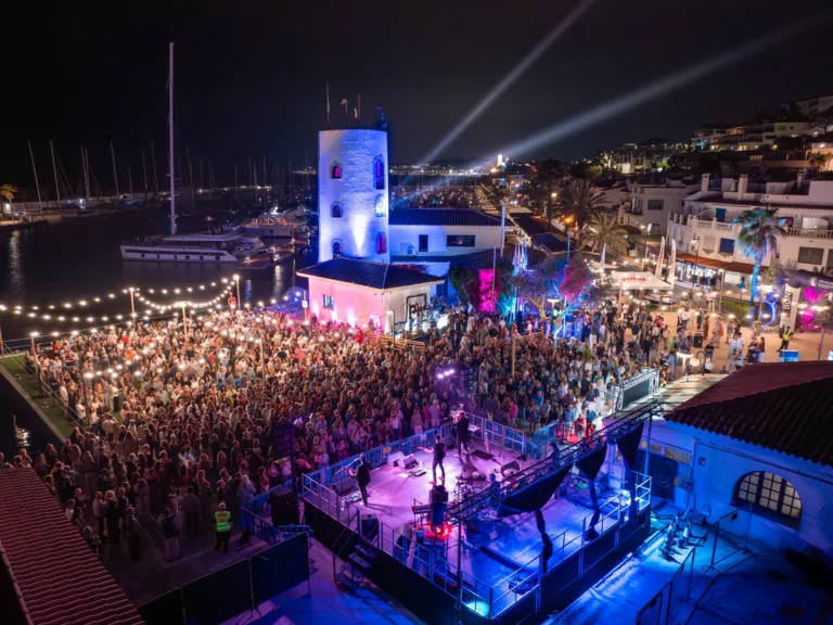Nächtliches Konzert der Concerts de Mitjanit im Hafen von Sitges Aiguadolç, mit Publikum und beleuchtetem Bühnenbereich