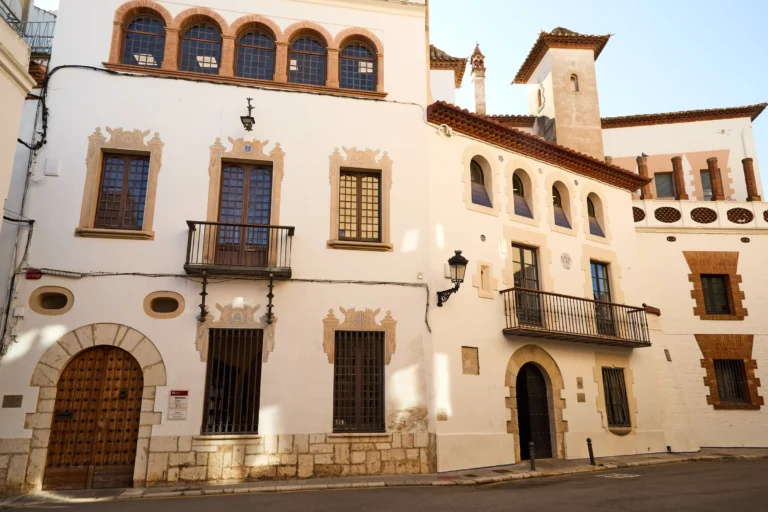 Fassaden historischer Gebäude in der Altstadt von Sitges mit Balkonen und traditioneller katalanischer Architektur.